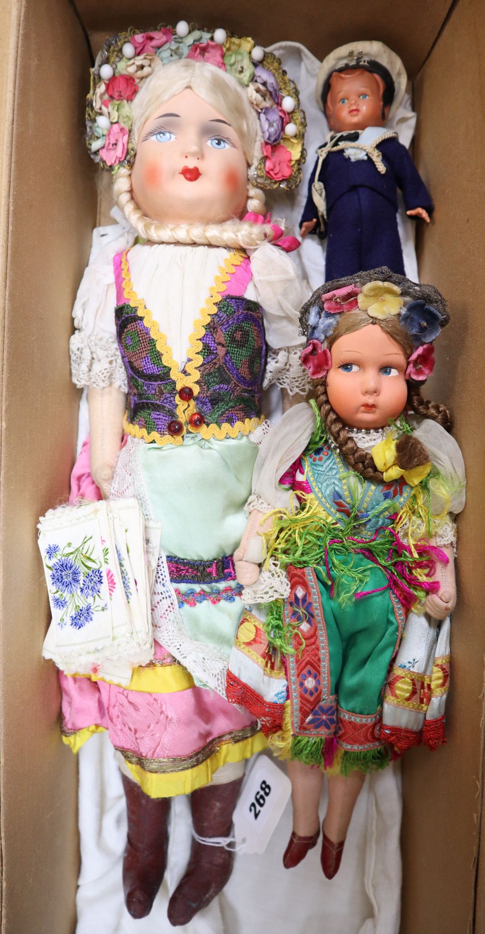 Two composition dolls, 1936, height 50cm and 32cm, a clockwork celluloid sailor doll, height 17cm and a collection of cigarette silks